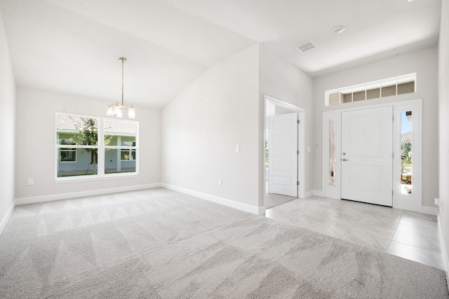 entryway featuring plenty of natural light, vaulted ceiling, light colored carpet, and an inviting chandelier