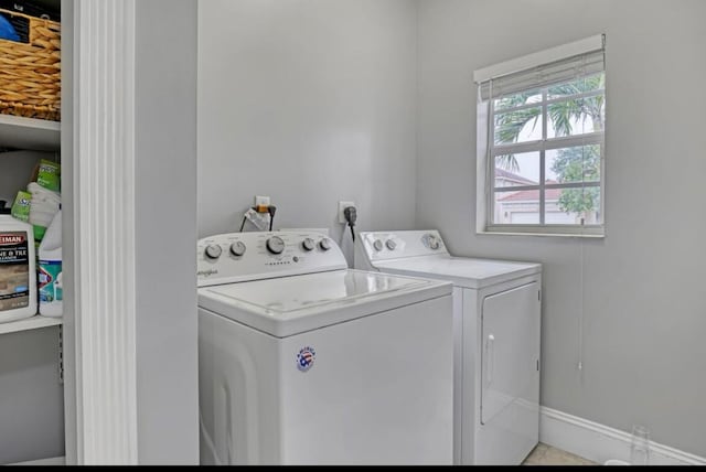 clothes washing area with light tile patterned flooring and washer and clothes dryer