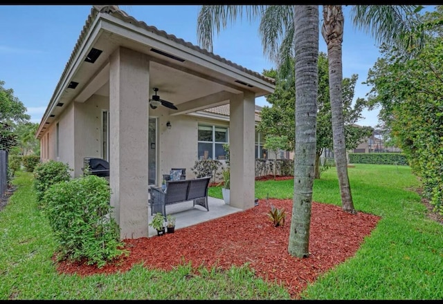 exterior space featuring a patio, outdoor lounge area, a yard, and ceiling fan