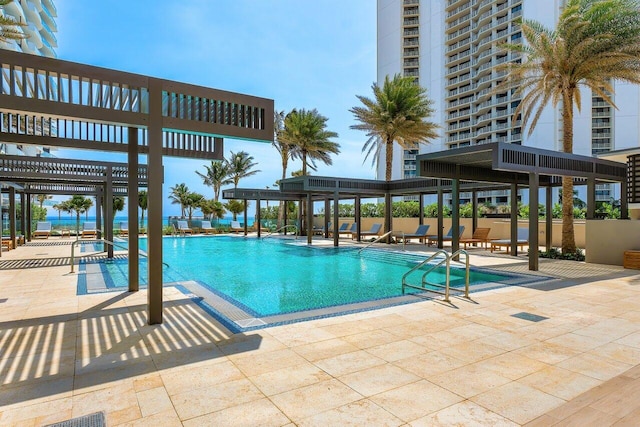 community pool with a patio area and a pergola