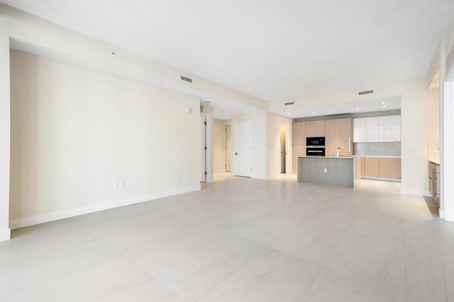 unfurnished living room featuring light tile patterned floors