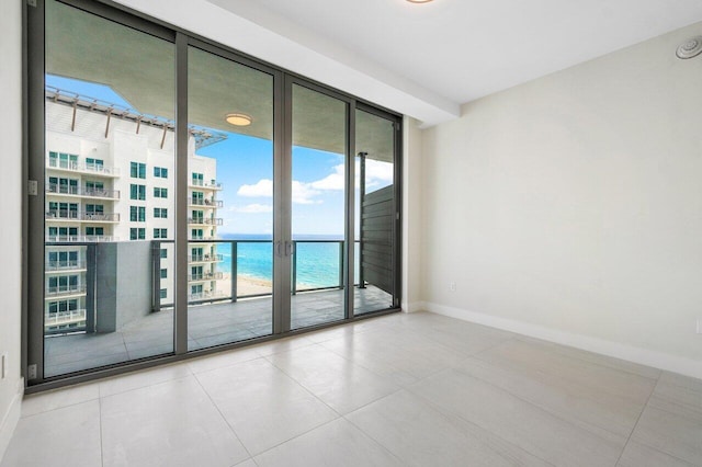 spare room featuring light tile patterned flooring and a water view