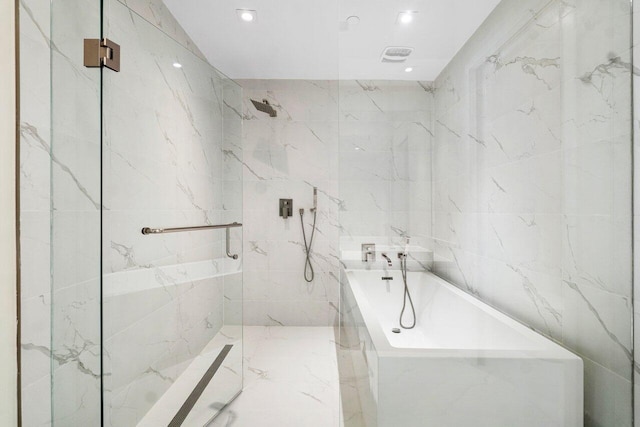 bathroom featuring plus walk in shower and tile walls