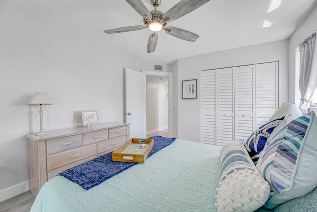 bedroom with hardwood / wood-style flooring, a closet, and ceiling fan