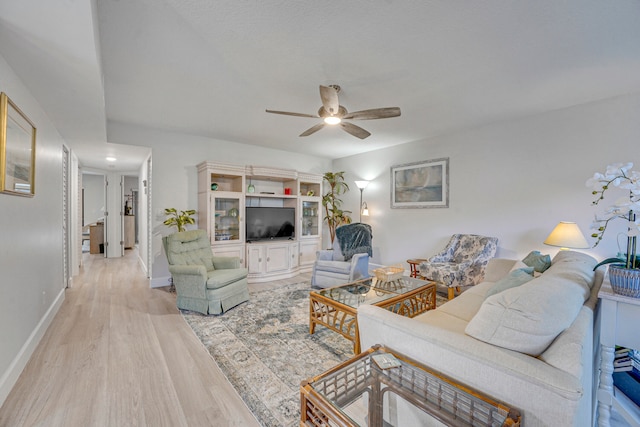 living room with ceiling fan and light hardwood / wood-style flooring