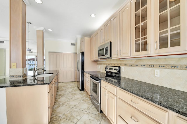 kitchen featuring dark stone countertops, crown molding, backsplash, stainless steel appliances, and sink