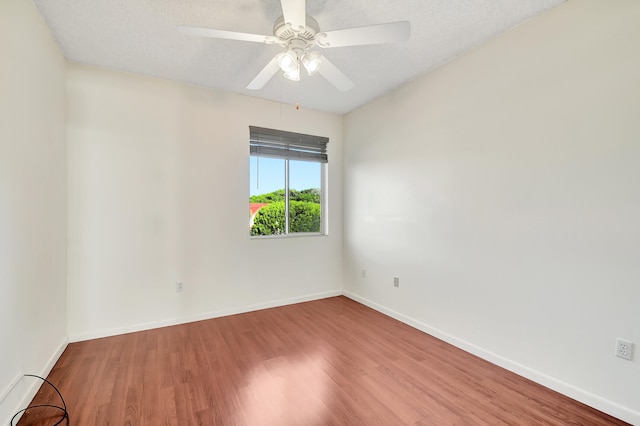 empty room with a textured ceiling, wood-type flooring, and ceiling fan