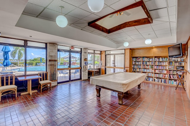 game room with billiards, plenty of natural light, and a drop ceiling