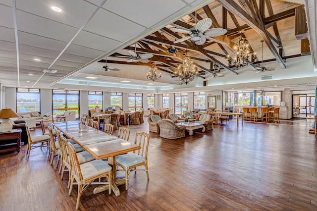 dining space featuring ceiling fan with notable chandelier, lofted ceiling, and hardwood / wood-style floors