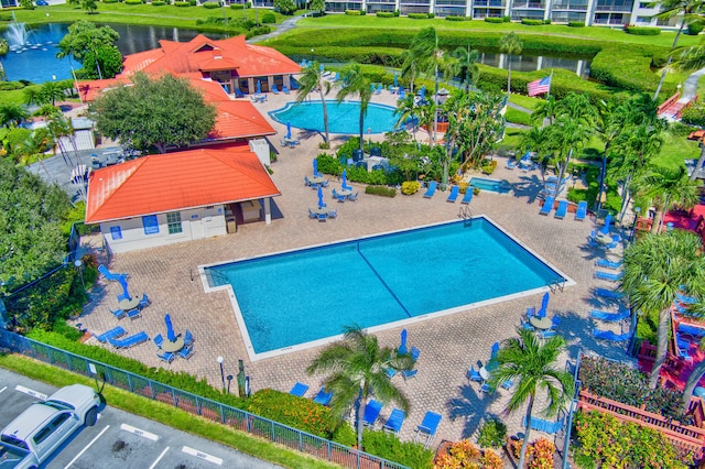 view of swimming pool featuring a patio and a water view