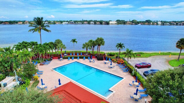 view of pool featuring a water view and a patio