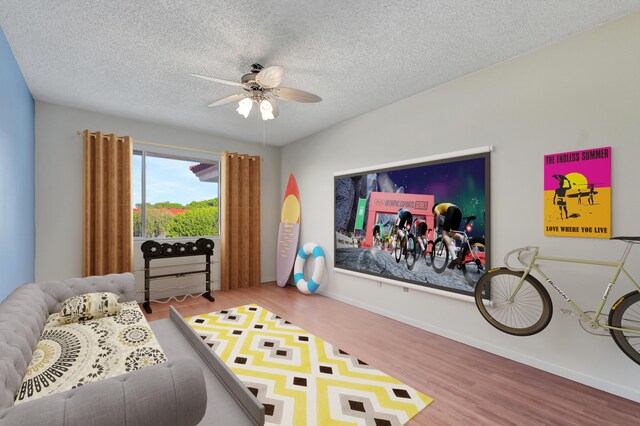 rec room with wood-type flooring, a textured ceiling, and ceiling fan