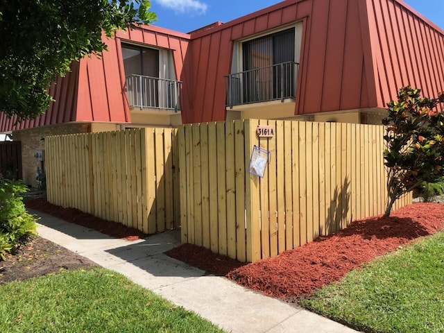 view of side of property with a lawn and fence