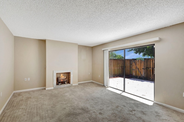 unfurnished living room with a fireplace, light colored carpet, and a textured ceiling