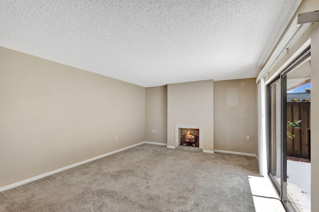 carpeted empty room featuring a textured ceiling and a chandelier