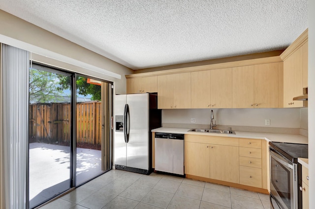 kitchen with light brown cabinets, sink, decorative light fixtures, light colored carpet, and stainless steel appliances