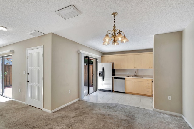 kitchen featuring sink, a textured ceiling, light brown cabinetry, light tile patterned floors, and appliances with stainless steel finishes