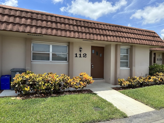 entrance to property with a lawn