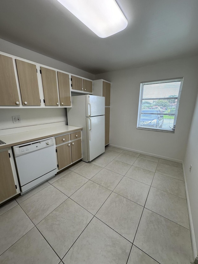 kitchen featuring light tile patterned floors and white appliances