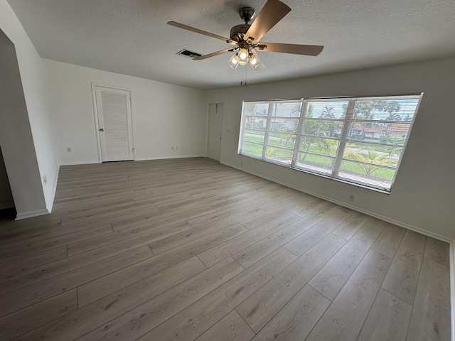 spare room featuring ceiling fan, a textured ceiling, and light wood-type flooring