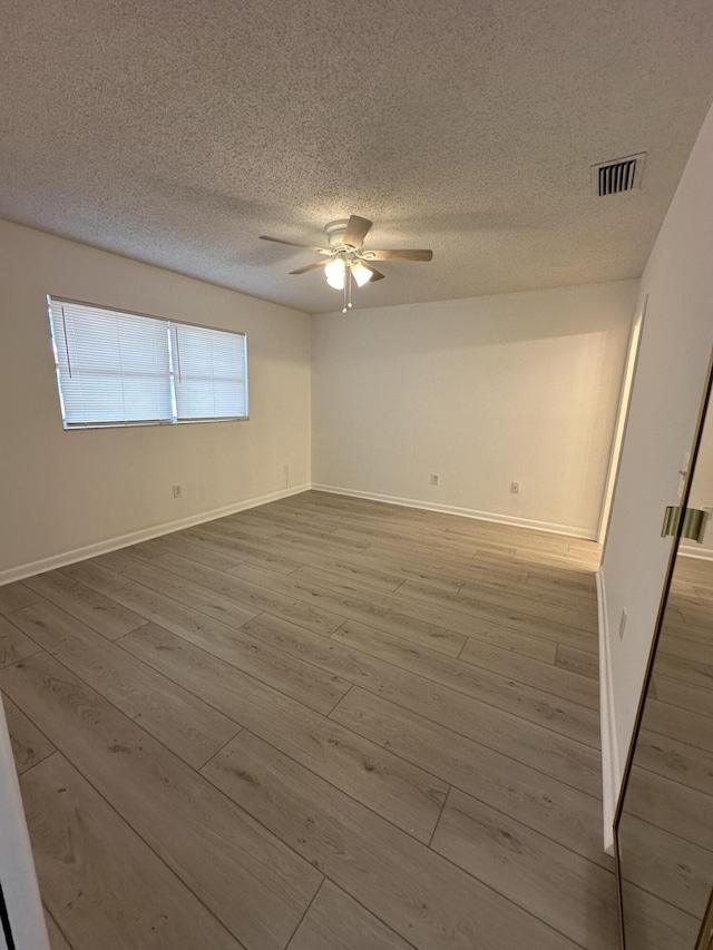 unfurnished room with hardwood / wood-style floors, a textured ceiling, and ceiling fan