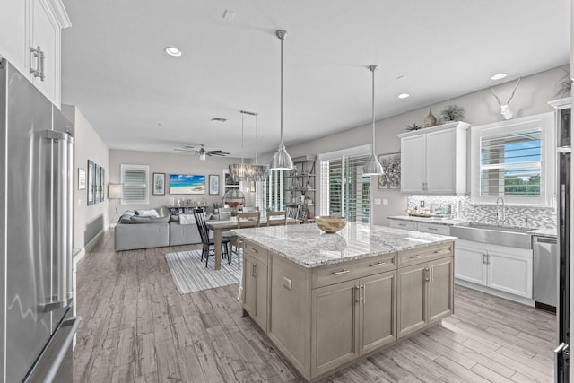 kitchen with stainless steel appliances, a kitchen island, and white cabinetry