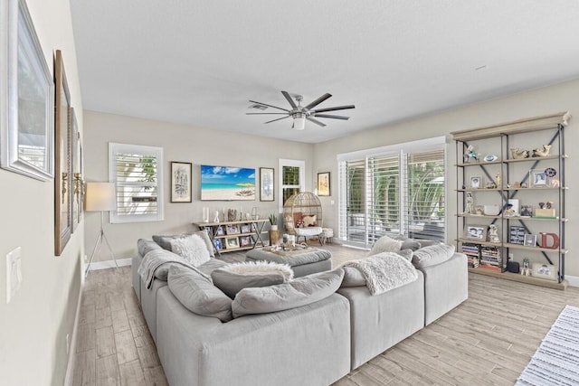 living room featuring ceiling fan and light hardwood / wood-style floors