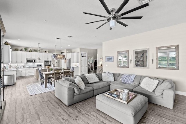 living room with ceiling fan and light hardwood / wood-style flooring