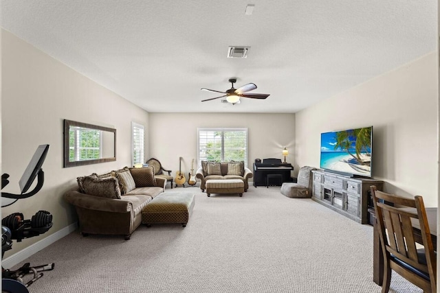 carpeted living room with ceiling fan and a textured ceiling