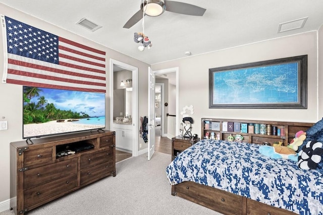 carpeted bedroom with ensuite bath and ceiling fan