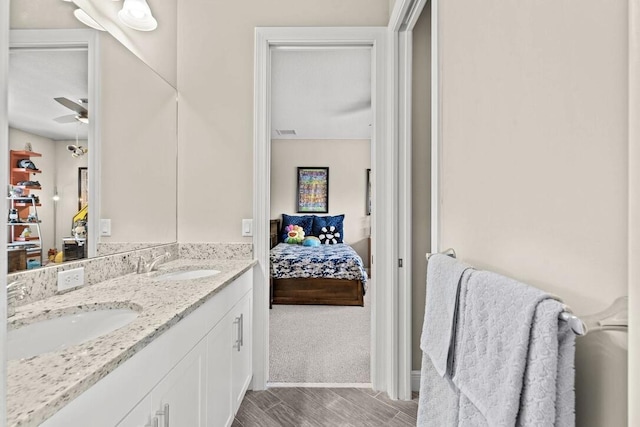 bathroom with hardwood / wood-style floors, ceiling fan, and vanity