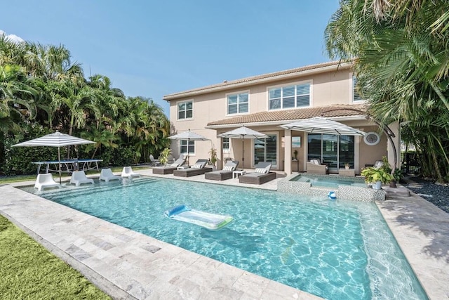 back of property with a patio and an outdoor living space