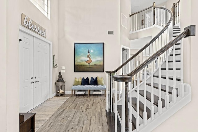 foyer featuring hardwood / wood-style floors and a towering ceiling