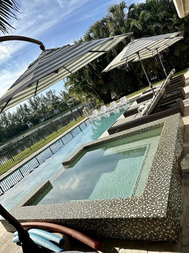 view of pool with an in ground hot tub