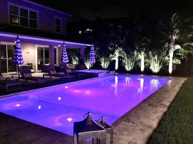 pool at twilight featuring a patio