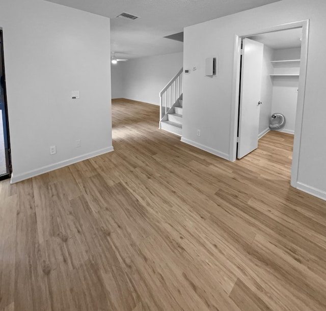 unfurnished living room with ceiling fan and light wood-type flooring