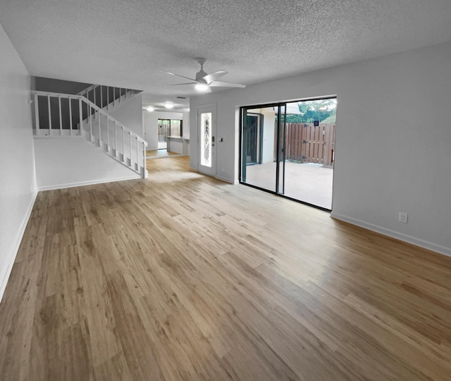 unfurnished living room with a healthy amount of sunlight, ceiling fan, light hardwood / wood-style flooring, and a textured ceiling