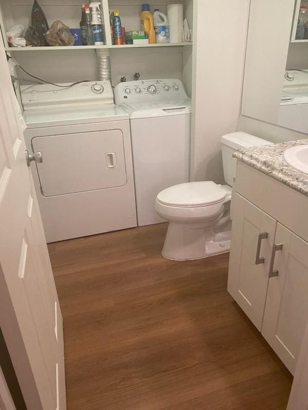 bathroom with vanity, wood-type flooring, independent washer and dryer, and toilet