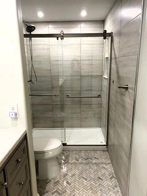 bathroom featuring vanity, a shower with shower door, toilet, and tile patterned floors