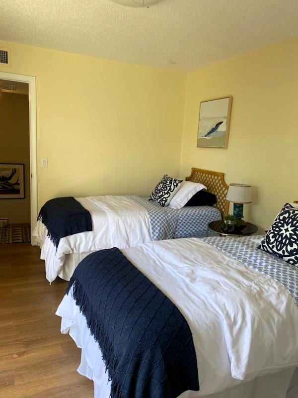 bedroom with hardwood / wood-style floors and a textured ceiling