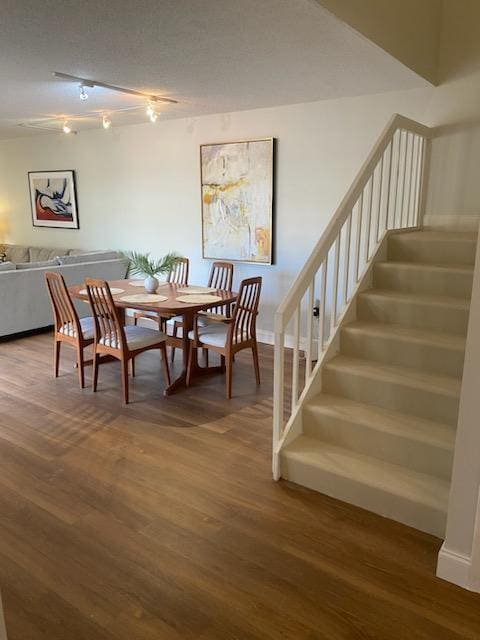 dining area featuring track lighting and hardwood / wood-style floors