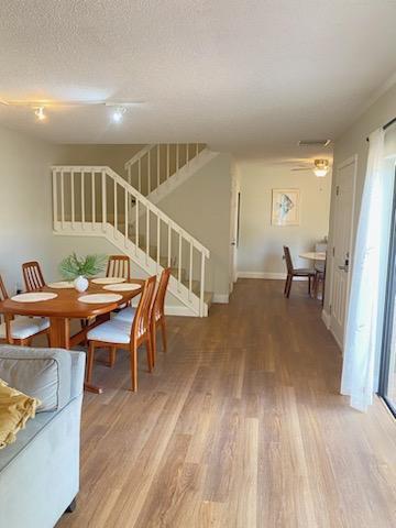 dining area featuring ceiling fan, hardwood / wood-style floors, and a textured ceiling