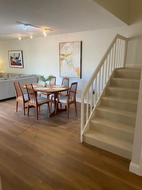 dining space with track lighting and wood-type flooring