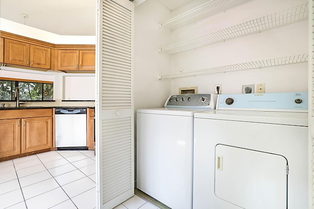 laundry area featuring sink, light tile patterned floors, and washer and dryer