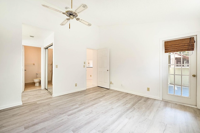 unfurnished bedroom with ensuite bath, access to outside, vaulted ceiling, and light wood-type flooring