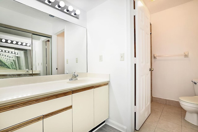 bathroom featuring tile patterned flooring, vanity, and toilet