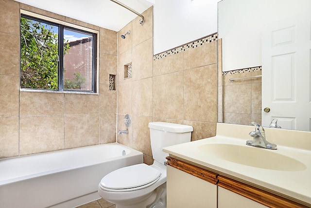 full bathroom featuring tile walls, vanity, tiled shower / bath, and toilet