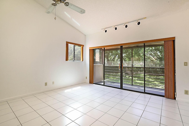 tiled empty room with lofted ceiling, ceiling fan, and a textured ceiling