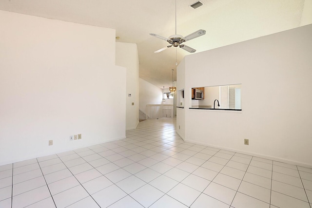 tiled empty room with high vaulted ceiling and ceiling fan