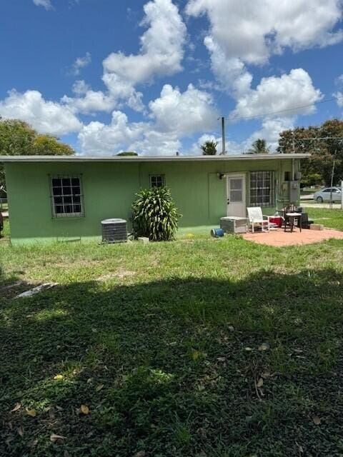 back of property with a patio, a lawn, and central AC unit